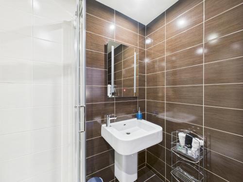 a bathroom with a white sink and a shower at The Auld Kirk in Ballater