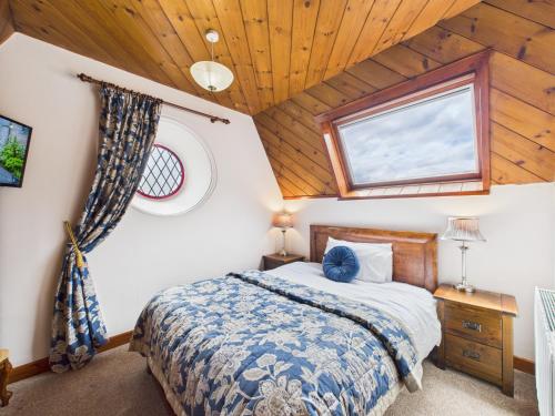 a bedroom with a bed in a wooden ceiling at The Auld Kirk in Ballater