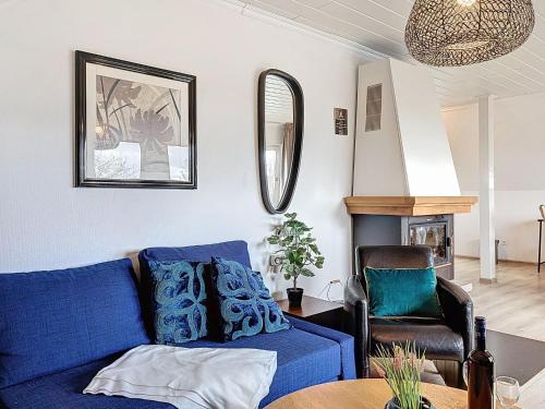 a living room with a blue couch and a chair at Apartment Am Sternberg 224 by Interhome in Frankenau