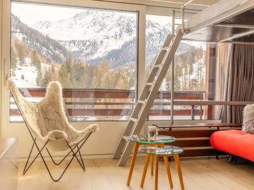 a room with a large window with a chair and a ladder at Studio Rosablanche D63 by Interhome in Siviez