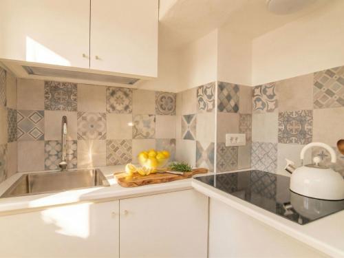 a kitchen with a sink and a bowl of fruit at Apartment Nautilus by Interhome in Arzachena