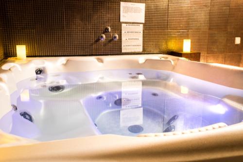 a jacuzzi tub in a bathroom with two lights at Hotel Cardamomo Sigüenza in Carabias