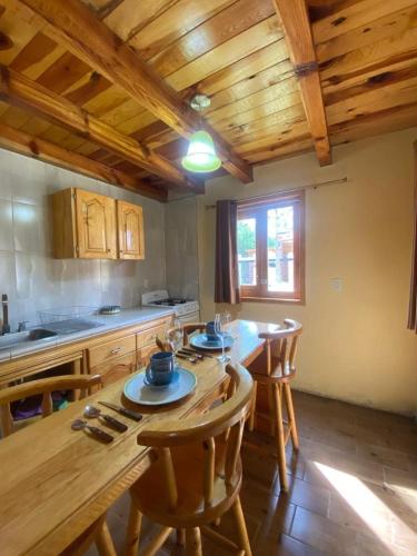 a kitchen with a wooden table and wooden ceilings at Vistas NO 5 in Mazamitla