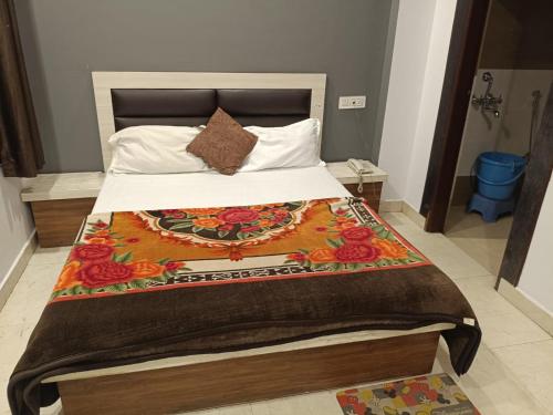 a bedroom with a large bed with a floral blanket at Hotel Sanwariya Palace in Haridwār