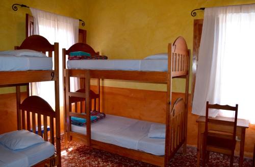 three bunk beds in a room with a window at Hostel Iguana Azul in Copan Ruinas