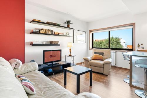 a living room with a couch and a tv at GuestReady - Seaside Experience in Moledo in Moledo