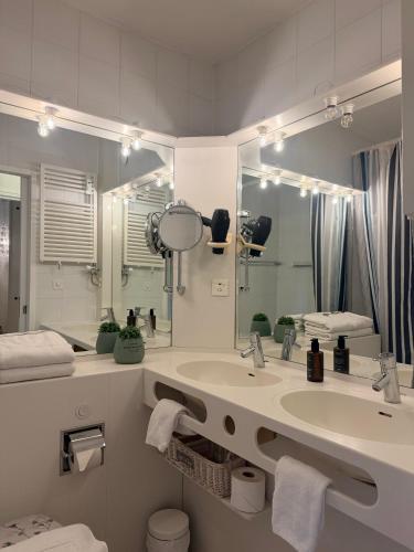 a bathroom with a sink and a large mirror at Holiday on The Lake Lugano 2 in Bissone