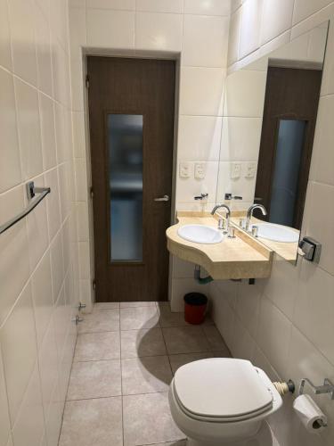 a bathroom with a toilet and a sink at Apart Hotel Veladero in San Juan