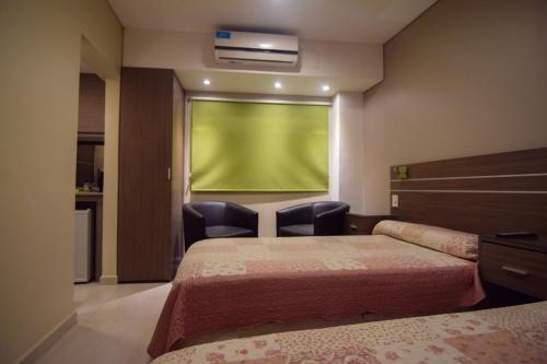 a room with two beds and a green screen at Apart Hotel Veladero in San Juan