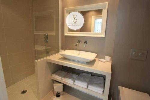 a bathroom with a white sink and a shower at Côté Chapelle Arles Centre in Arles