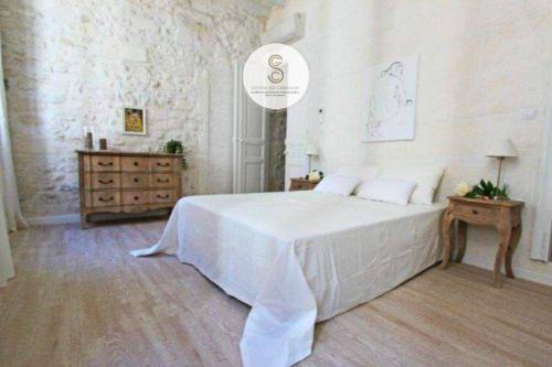 a bedroom with a large white bed and a dresser at Côté Chapelle Arles Centre in Arles