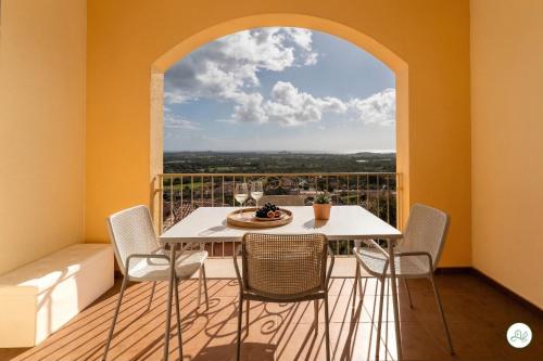 a table and chairs in a room with a window at Luce di Mare, Vista Mare Sea View in Is Molas 