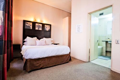 a bedroom with a large bed and a glass shower at Isiphephelo Property in Johannesburg