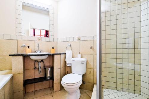 a bathroom with a toilet and a sink and a shower at Isiphephelo Property in Johannesburg