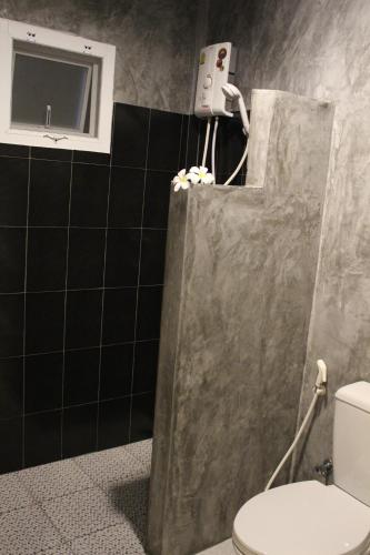 a bathroom with a shower with a toilet and a window at Phuket Muay Thai House in Chalong 