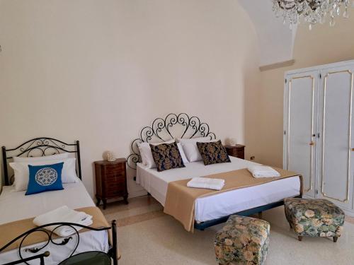 a bedroom with two beds and a chandelier at Suite Verdi suite room in Lecce