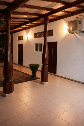 a room with two wooden columns and a ceiling at Robert's-stay in Katunayaka