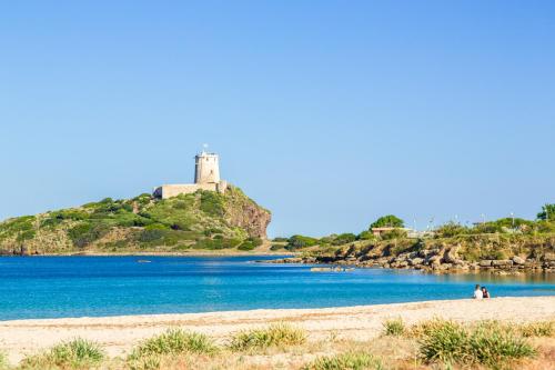 a view of a beach with a castle on a hill at Luce di Mare, Vista Mare Sea View in Is Molas 