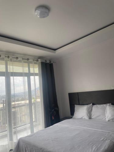 a bedroom with a bed and a large window at Kigali Legacy Villa Homes in Kigali