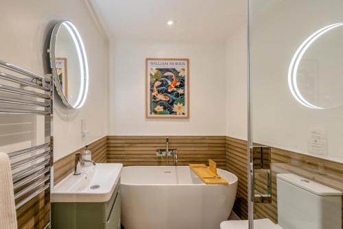 a bathroom with a tub and a sink and a mirror at 3 Bed in Putsborough oc-flt20 in Croyde