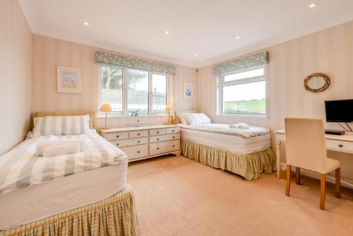 a bedroom with two beds and a desk and a television at 3 Bed in Putsborough oc-flt20 in Croyde