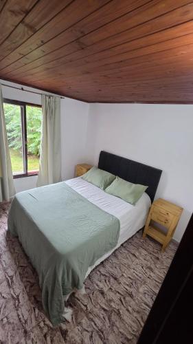 a bedroom with a large bed with a wooden ceiling at CASA ANTONIA in Embalse