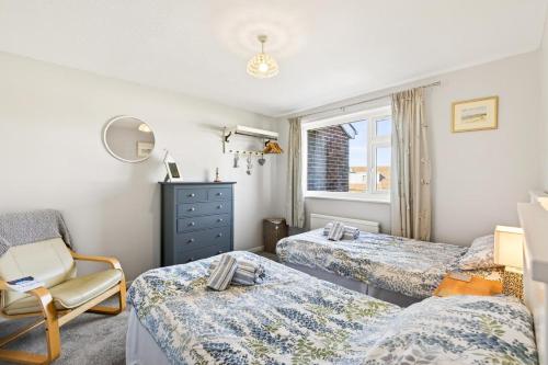 a bedroom with two beds and a chair and a window at 2 Bed in Seahouses oc-86092 in North Sunderland