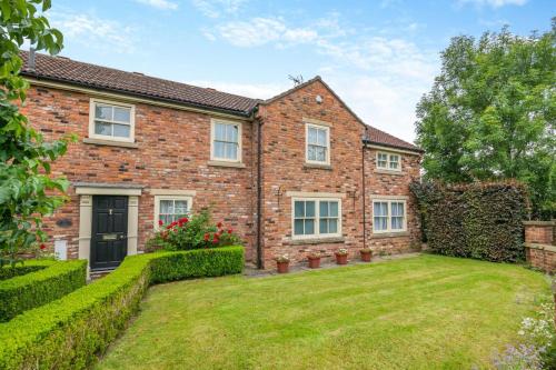 an exterior view of a brick house with a yard at 4 Bed in Helmsley oc-y039 in Helmsley