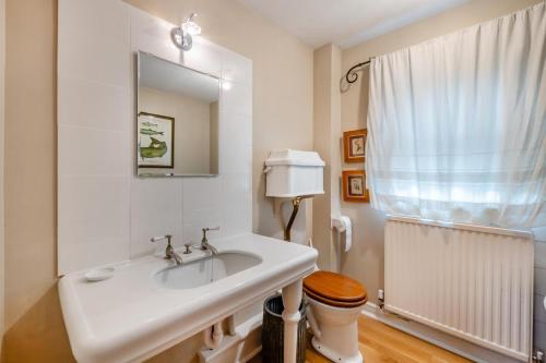 a bathroom with a sink and a toilet and a mirror at 4 Bed in Helmsley oc-y039 in Helmsley