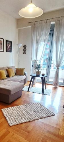 a living room with a couch and a table at Sunny place in Podgorica