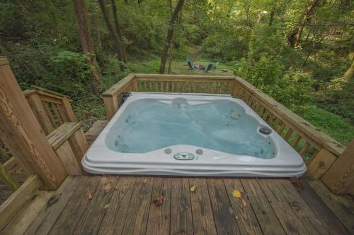 a jacuzzi tub on a deck in the woods at Gabriele Cabin Rustic Retreat Near Downtown in Chattanooga