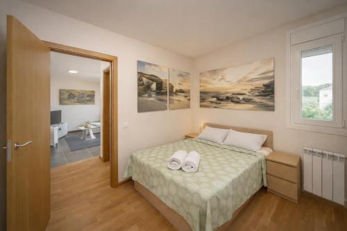 a bedroom with a bed with two white towels on it at Nova MSuites Catedrales in Foz