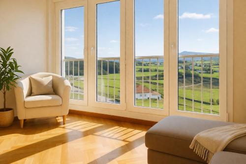 a living room with large windows and a chair at Nova MSuites Catedrales in Foz
