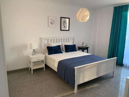 a bedroom with a large bed with blue pillows at PP Apartments Deluxe in Năvodari
