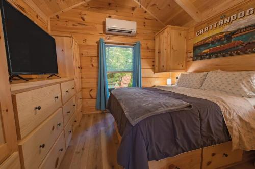 a bedroom with a bed and a flat screen tv at Celina Cabin Nature Cabin Near Downtown Chattanooga in Chattanooga