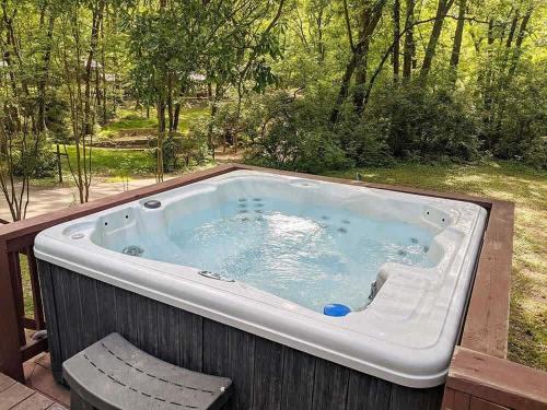a hot tub sitting on a deck with a chair at Celina Cabin Nature Cabin Near Downtown Chattanooga in Chattanooga