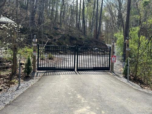 a black gate in a driveway with trees at Serenity at the Smokies in Sevierville