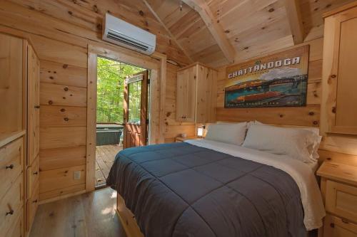 a bedroom with a bed in a wooden cabin at Apollonie Cabin Lookout Mountain Hot Tub in Chattanooga