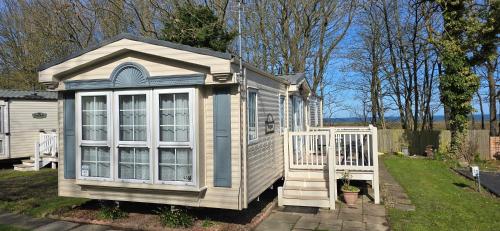 a small house with a porch and a white door at The Finest Hour in Cresswell