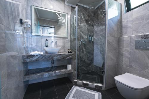 łazienka z umywalką, prysznicem i toaletą w obiekcie Hotel Villa Nisteri w mieście Limenas