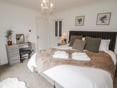 a bedroom with a large bed with towels on it at Willows Lodge at Carreg Llwyd in Cardiff