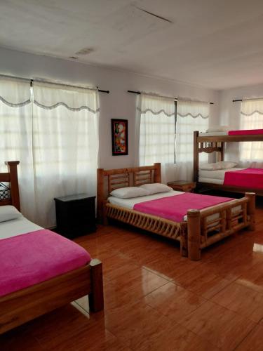 a bedroom with two beds with pink sheets at Finca Montenegro Quindio in Montenegro