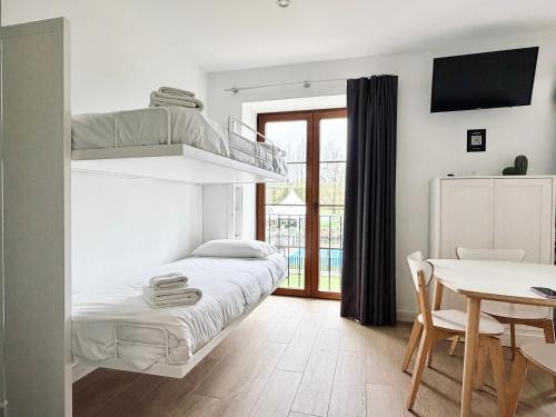 a bedroom with a bunk bed and a table at Jardines Villaverde in Villaverde de Pontones