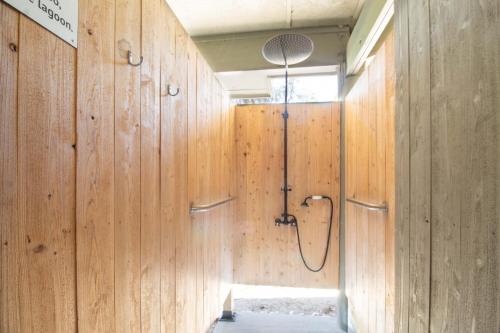 a bathroom with wooden walls and a shower stall at 611 Magnolia-Stella Maris in Edisto Island