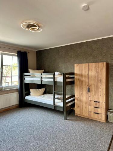 a room with two bunk beds and a cabinet at Holiday Park Auf dem Simpel in Soltau