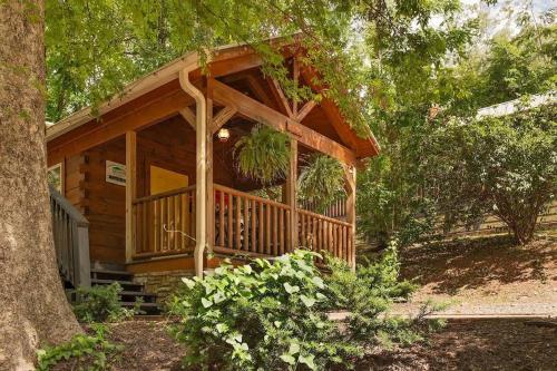 a log cabin with a porch and a tree at Ani Cabin Tiny Home Bordered By National Forest in Chattanooga