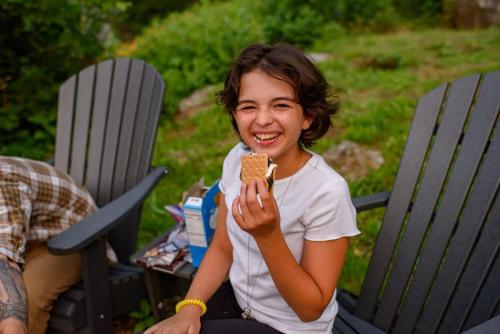 a woman sitting in a chair eating a piece of food at Historic Riverview Inn Suite Nine in Chattanooga