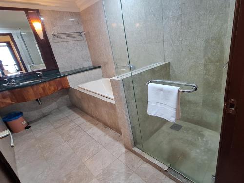 a bathroom with a shower and a tub and a sink at Sunshine Suites Times square KL in Kuala Lumpur