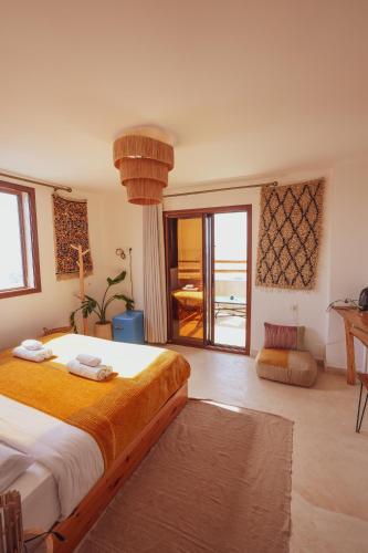a bedroom with a large bed and a balcony at Aman surf paddle yoga in Imsouane