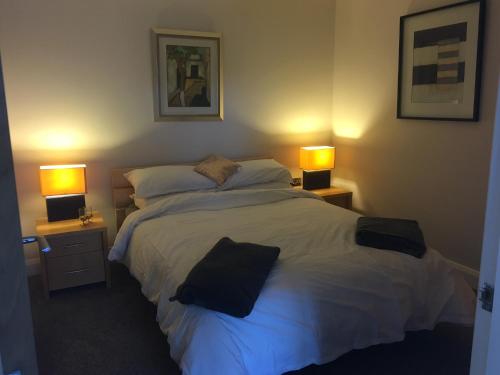a bedroom with a large bed with two lamps at Lakeside Apartment in Enniskillen